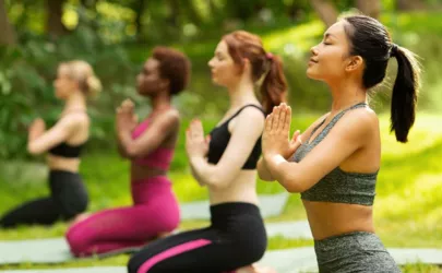 Vier Frauen machen zusammen Yoga in der Natur